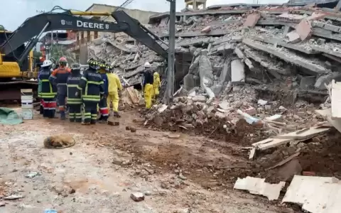 Bomberos trabajan para retirar el cuerpo de entre los escombros.