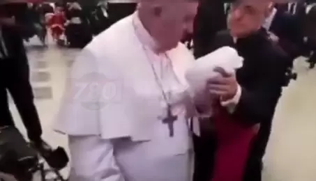 Momento en que el papa Francisco se levanta de sus silla de ruedas para retirar las chipas.