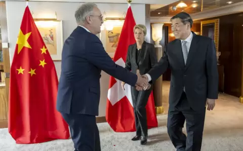 El ministro de Econom�a de Suiza, Guy Parmelin (izquierda), estrecha la mano del vice primer ministro chino, He Lifeng, junto a la presidenta de Suiza