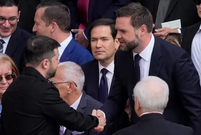 Saludo entre el presidente de Ucrania, Zelensky, y el vicepresidente de EEUU JD Vance, bajo la mirada del Secretario de Estado de EEUU Marco Rubio