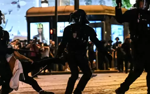Tres agentes trasladan a un detenido en los Campos El�seos de Par�s.