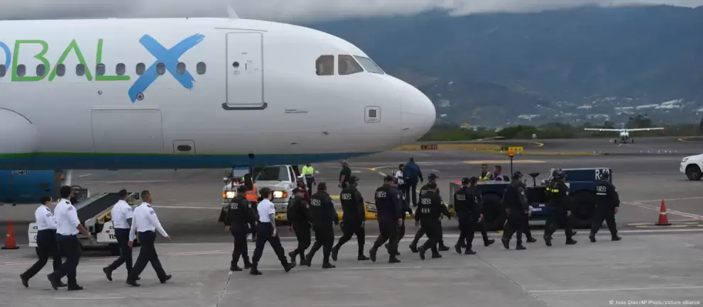 Personal de seguridad se acerca a un avi�n que transporta migrantes de Asia Central e India, deportados desde EE.UU, en el Aeropuerto en San Jos�.