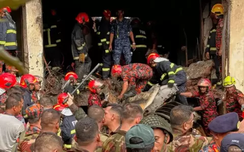 Un cuerpo de rescate y bomberos rastrea entre los restos del avi�n estrellado en Daca, Banglad�s.