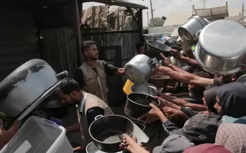 Un grupo de palestinos espera por comida en Jan Yunis, en la Franja de Gaza.