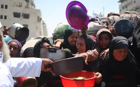 Palestinos esperan para recibir comida en un comedor social.