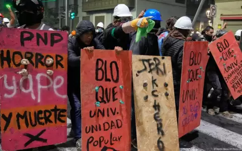 Manifestantes se refugian de la polic�a tras carteles que les sirven de escudos durante una protesta contra el nuevo presidente Jos� Jeri,en Lima,Per�