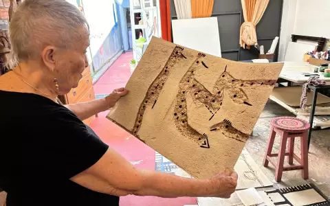 Lucy Yegros y una de las obras exhibidas en la muestra.