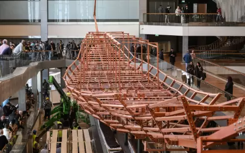 Empleados del museo instalan antiguas tablas de madera del segundo barco del rey Keops.