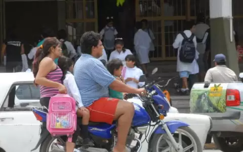Una familia trasladandose en una motocicleta sin casco.