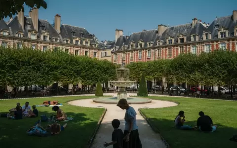 Personas sentadas a la sombra de los �rboles en la Place des Vosges, Par�s.