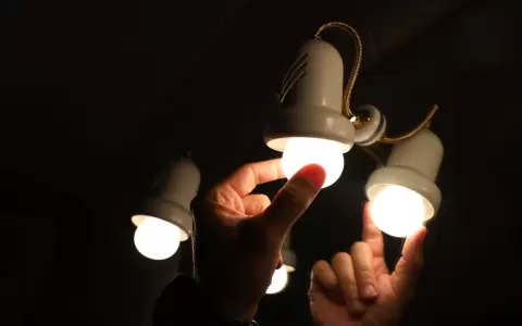 Una persona cambia la bombilla de una l�mpara, el d�a en que el precio de la luz bate un r�cord hist�rico.