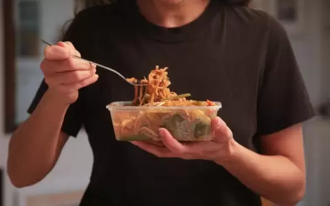 Chica comiendo un plato preparado de espagueti.