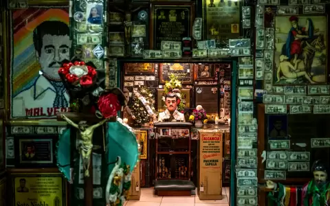 Ofrendas de flores, velas, fotos y billetes de d�lar en un santuario dedicado a Jes�s Malverde, un "narcosanto",en Culiac�n, M�xico, el 25 de nov 2024