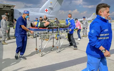 Miembros de la Fuerza Aeroespacial Colombiana y param�dicos transportando a una persona herida en la base a�rea CATAM en Bogot�, Colombia.