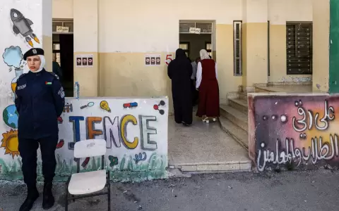 Un miembro de las fuerzas de seguridad palestinas custodia la entrada a un colegio electoral.