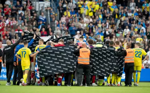 Los jugadores de Dinamarca y Ucrania agrupados para acompa�ar al dan�s Christian Eriksen.
