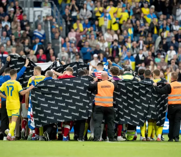 Los jugadores de Dinamarca y Ucrania agrupados para acompa�ar al dan�s Christian Eriksen.