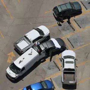 Vista a�rea de trabajadores forenses inspeccionando un autom�vil donde se hall� un cuerpo en un estacionamiento frente al estadio Caliente.