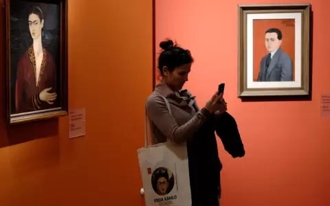Visitante frente al "Autorretrato con vestido de terciopelo" de Frida Kahlo.
