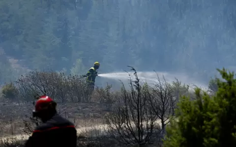 Un bombero franc�s roc�a agua para extinguir un incendio forestal cerca de Trevillach, en el sur de Francia.