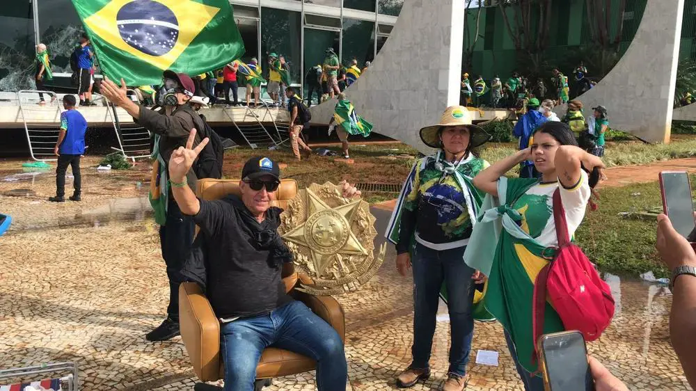 Sobre el sillón del presidente del Supremo Tribunal, posando junto al Escudo de la República arrancado de la pared. Cortesía