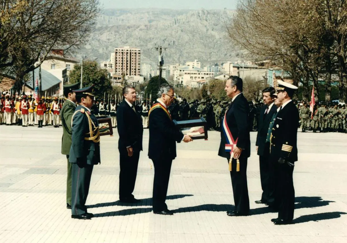 El presidente Gonzalo S�nchez de Losada entrega al presidente Juan Carlos Wasmosy las banderas paraguayas tomadas en la batalla de Ca�ada Strongest, durante la ceremonia de devoluci�n de los trofeos de guerra. La Paz, agosto de 1994. Cortes�a
